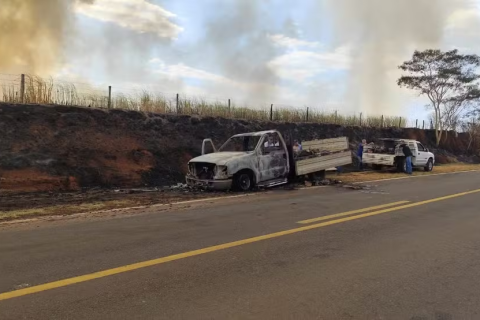 Caminhonete pega fogo com materiais de construção às margens de rodovia e chamas atingem canavial